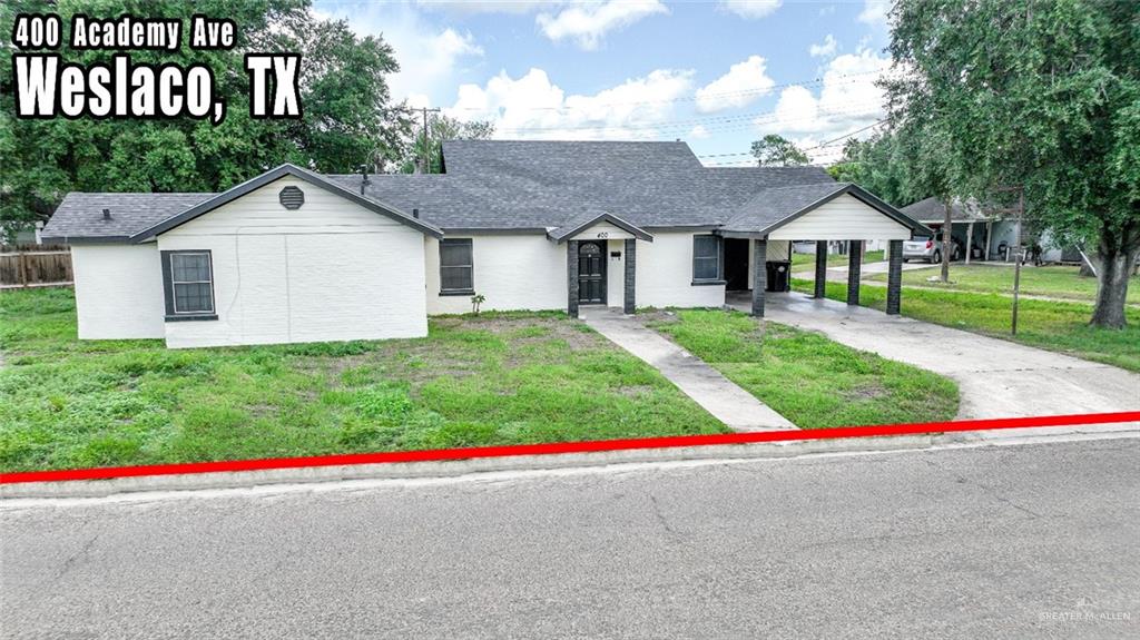 View of front facade featuring a carport and a front lawn