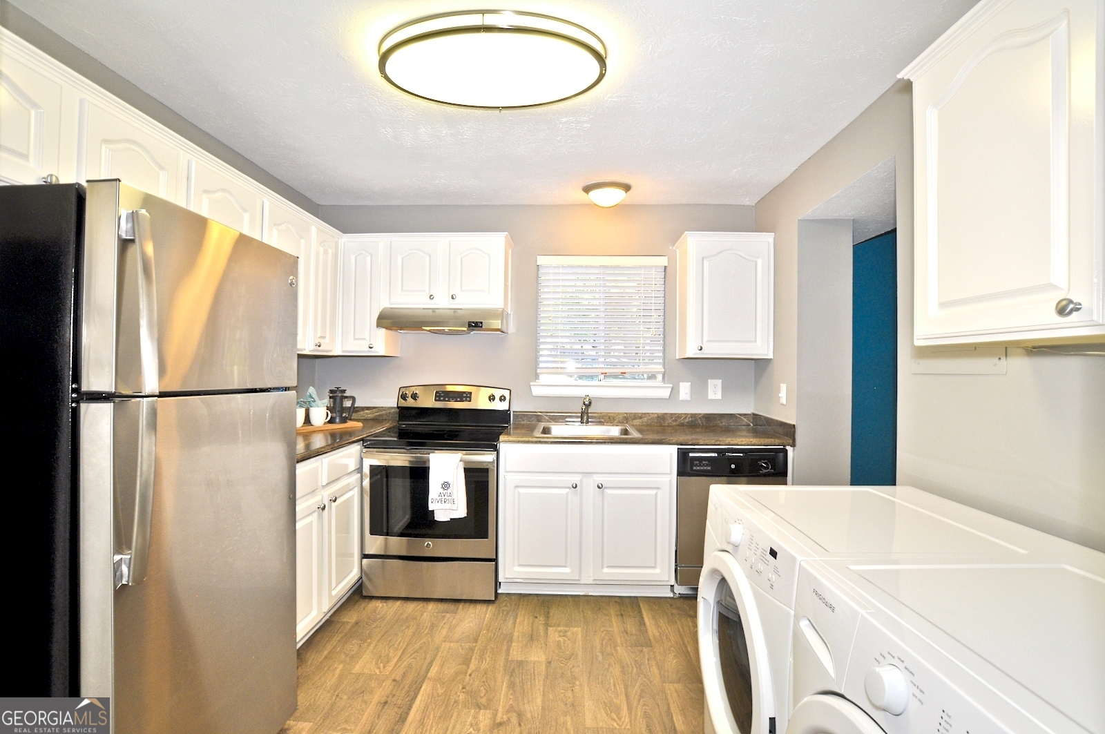 a kitchen with a refrigerator a stove a sink and a cabinets