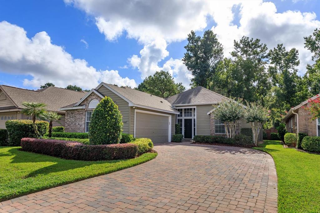 a front view of a house with a yard and trees