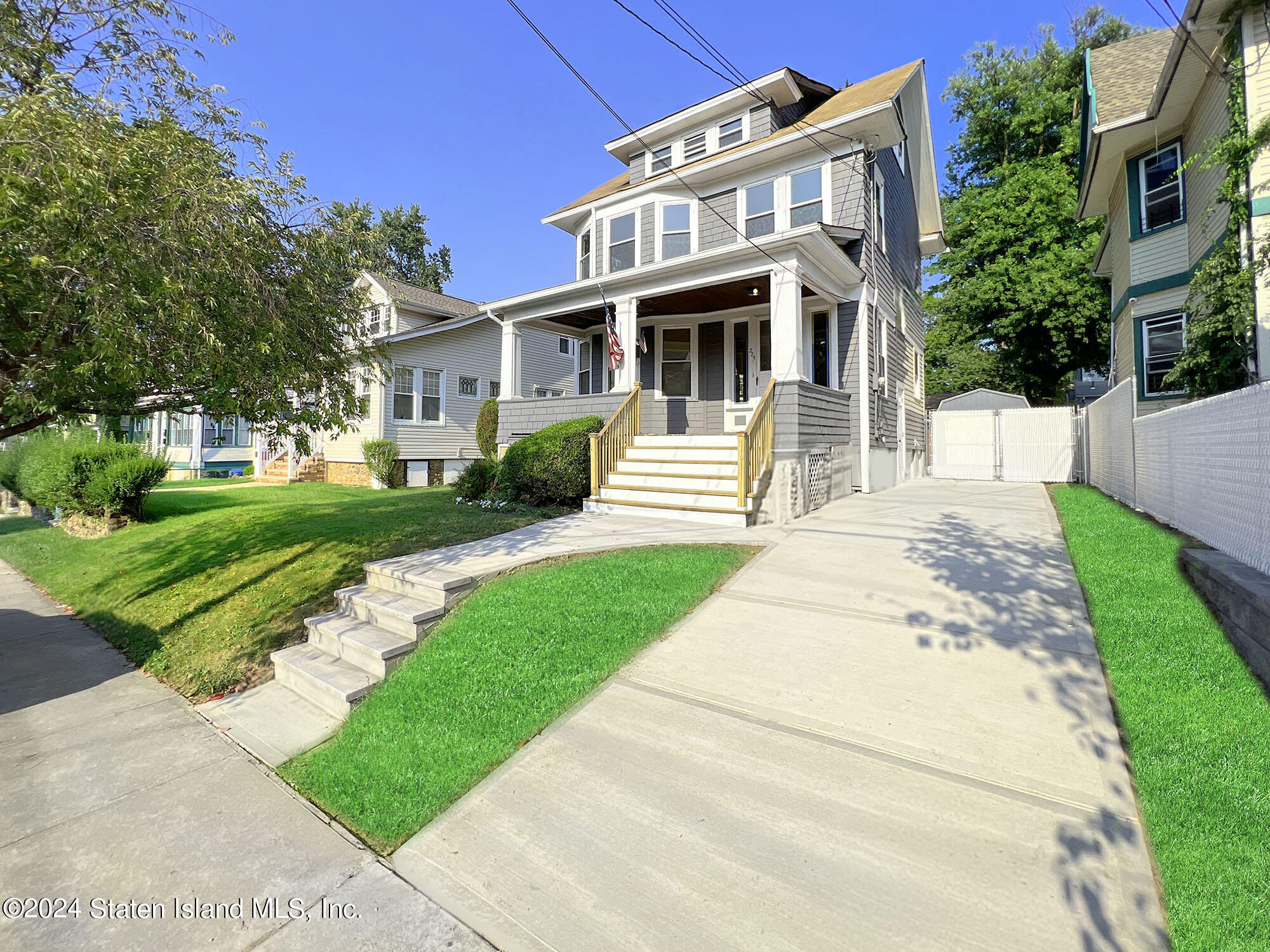 a front view of a house with a yard and potted plants