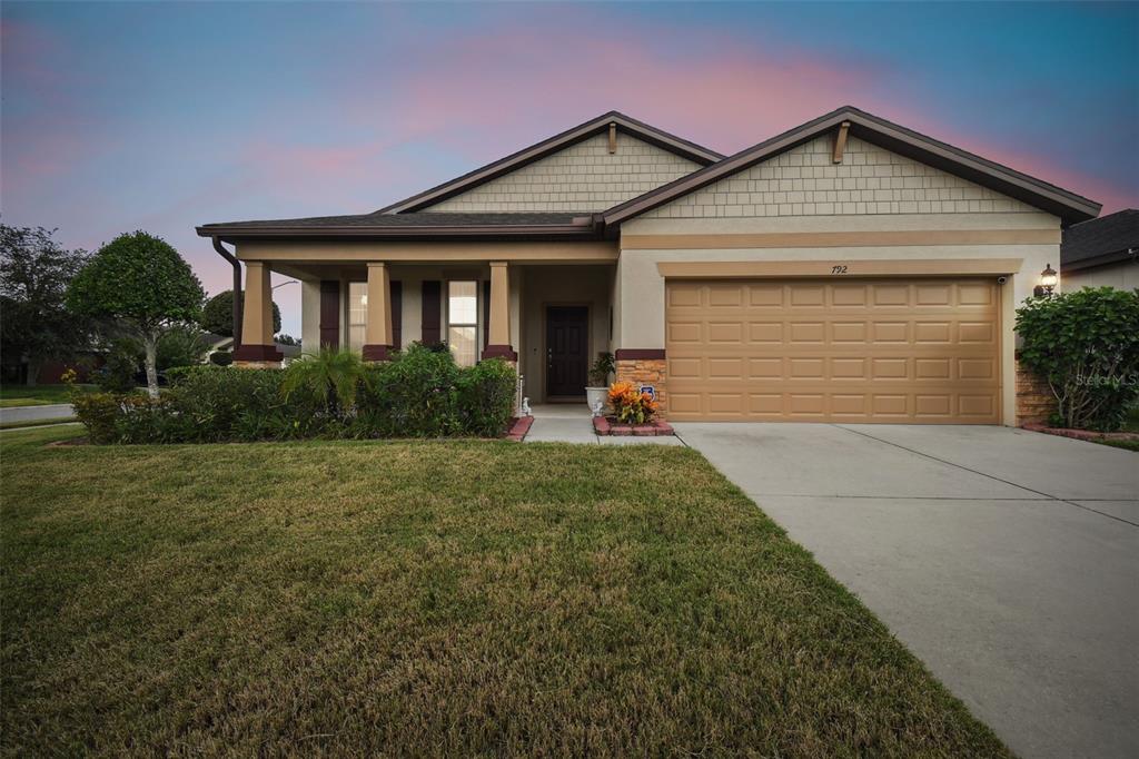 a front view of a house with a yard and garage