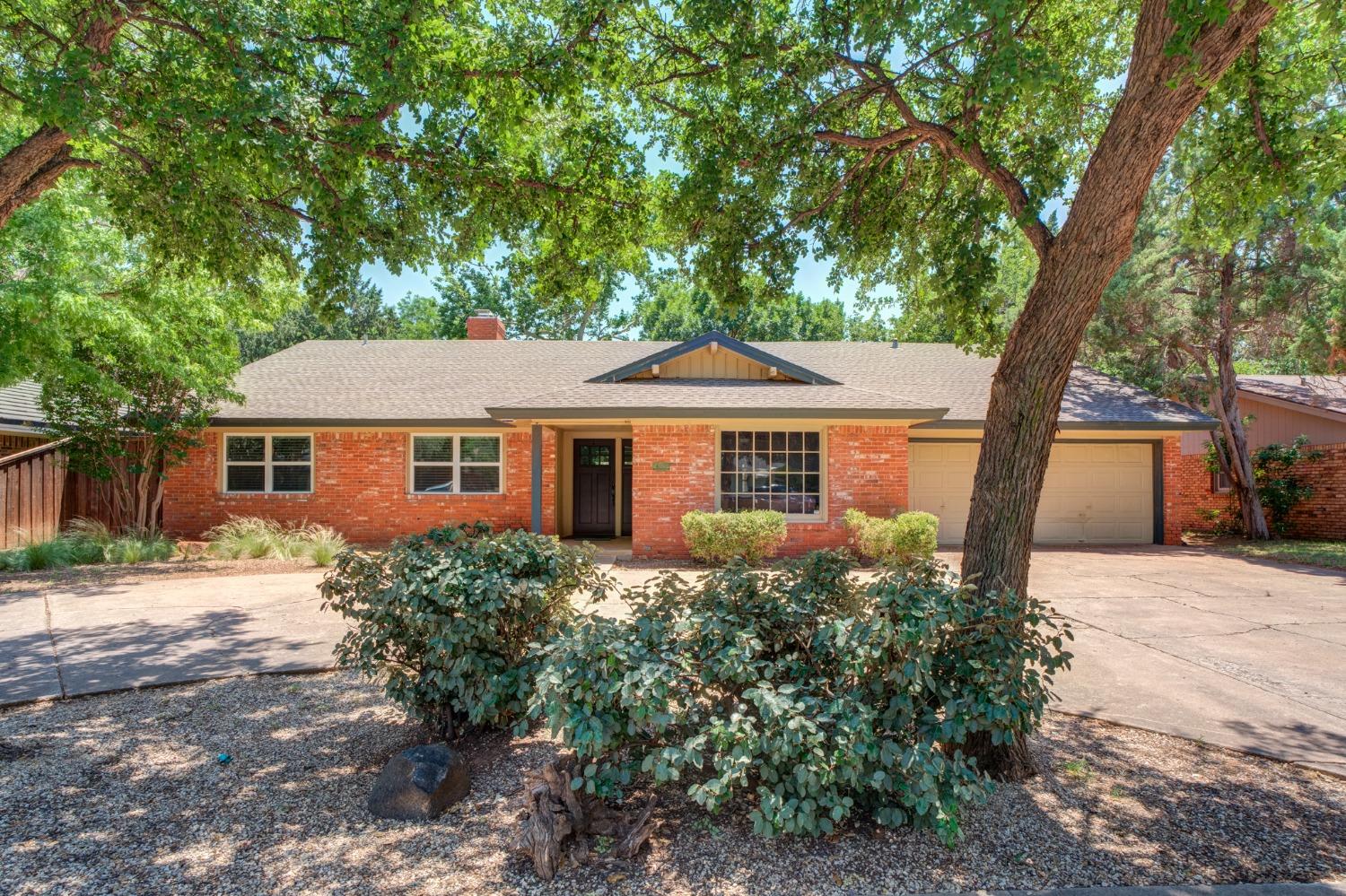 a front view of a house with a yard and trees