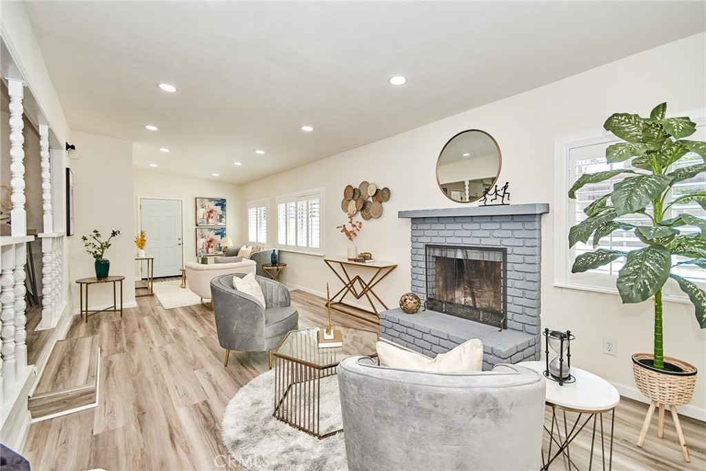 a living room with furniture a fireplace and a potted plant