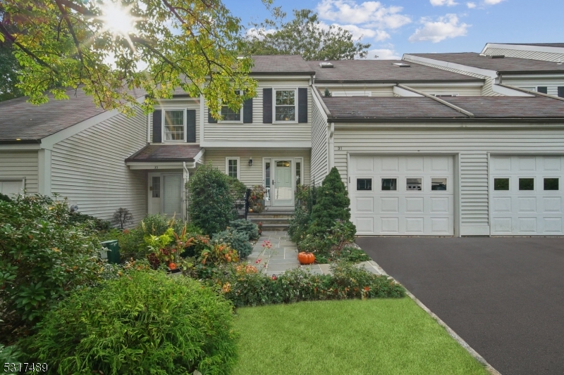 a front view of a house with a yard and trees