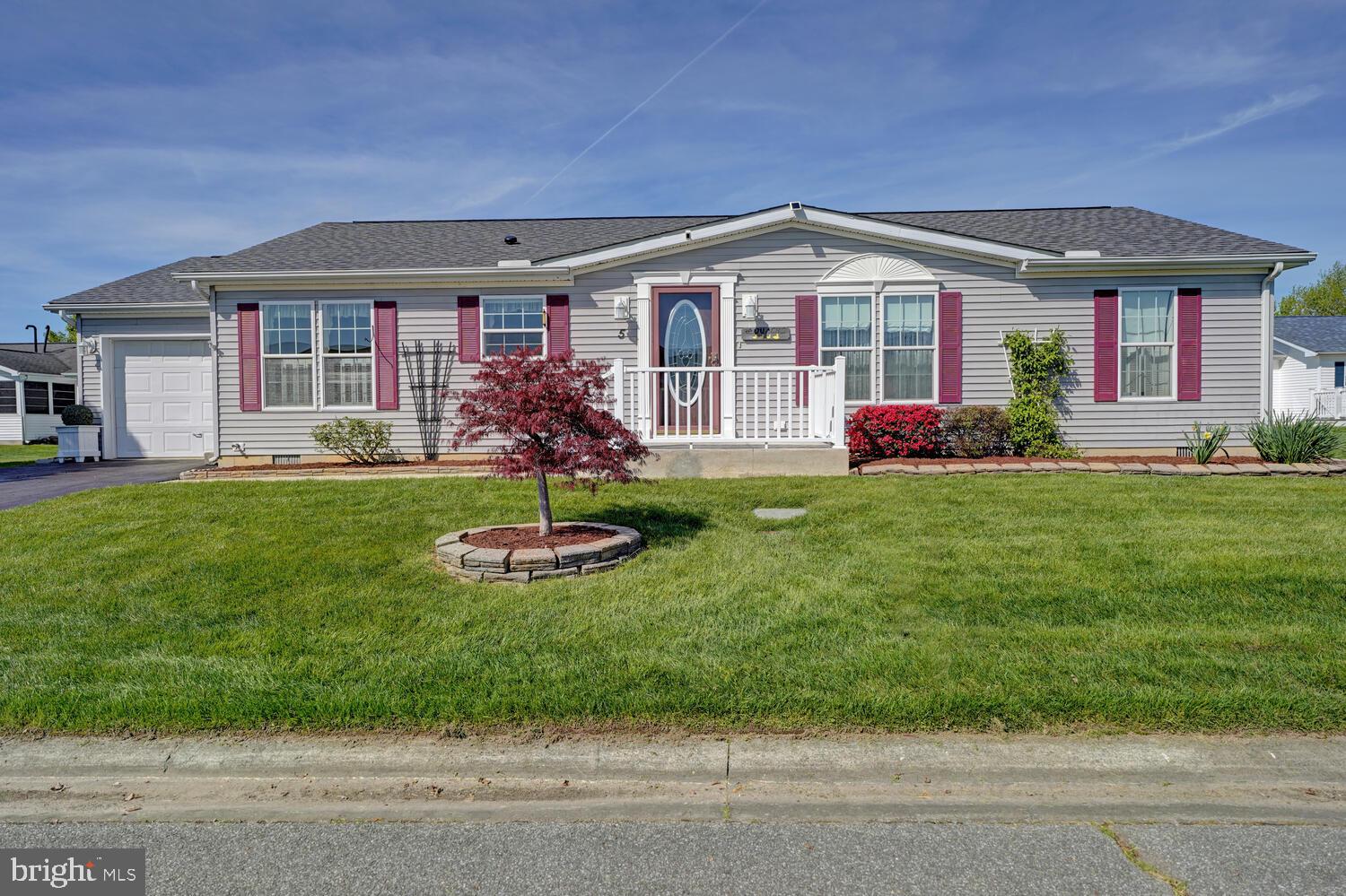 a front view of a house with a yard porch and outdoor seating