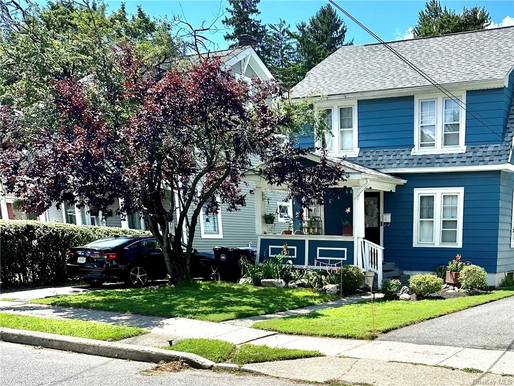 a front view of a house with a yard and potted plants