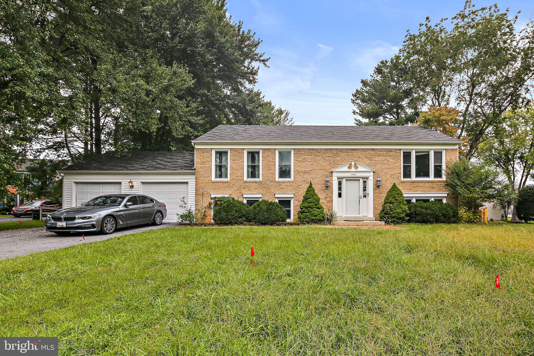 a view of a house with a big yard and large trees