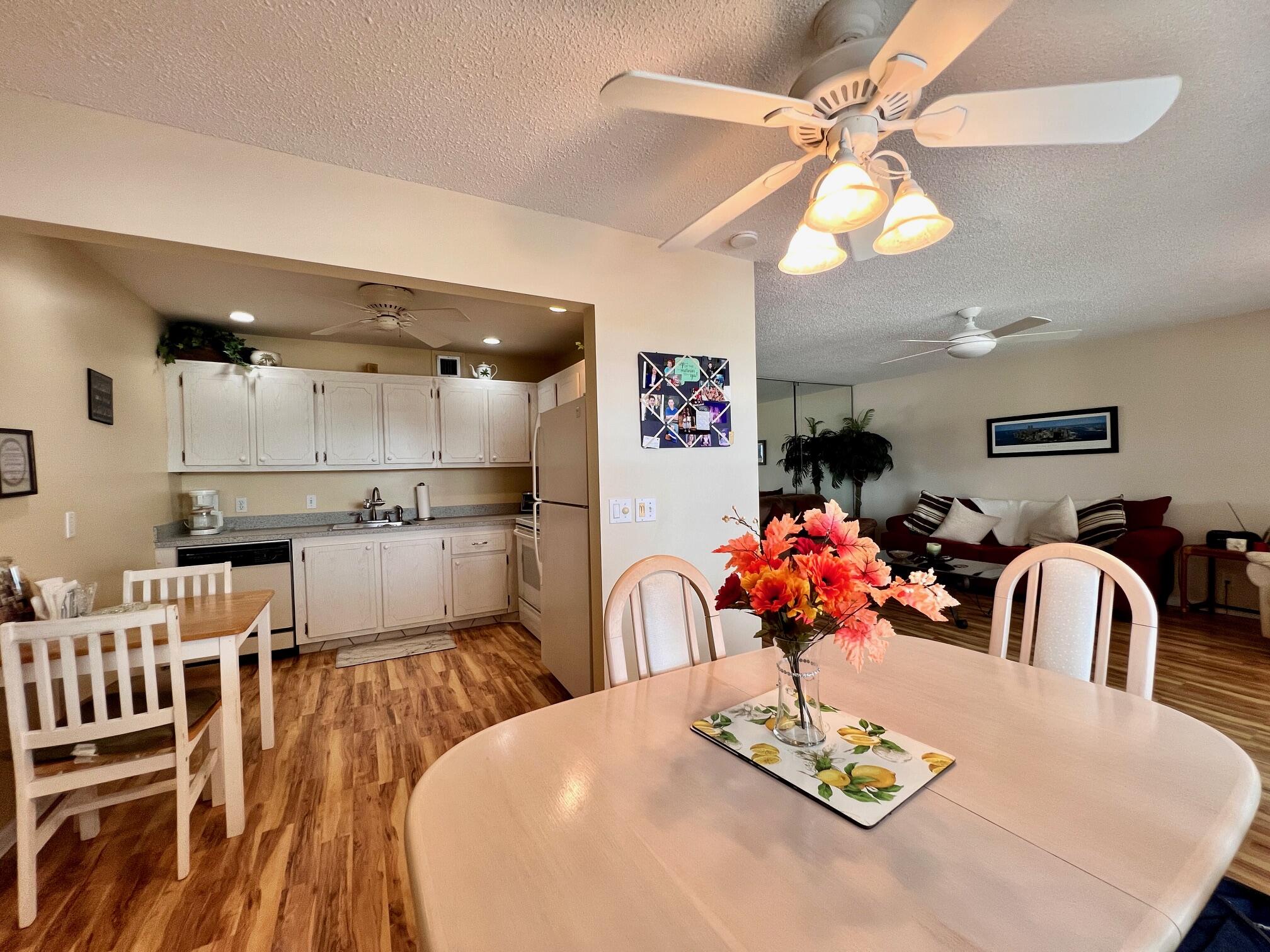 a kitchen with stainless steel appliances kitchen island granite countertop a dining table and chairs with wooden floor