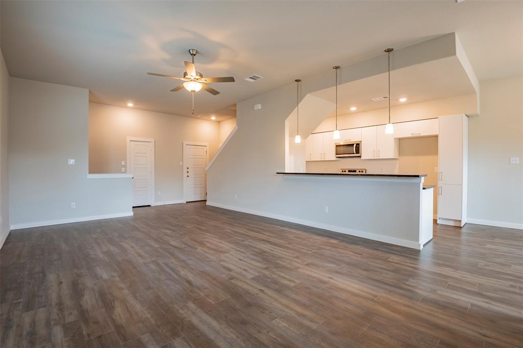 an open kitchen with a window and wooden floor