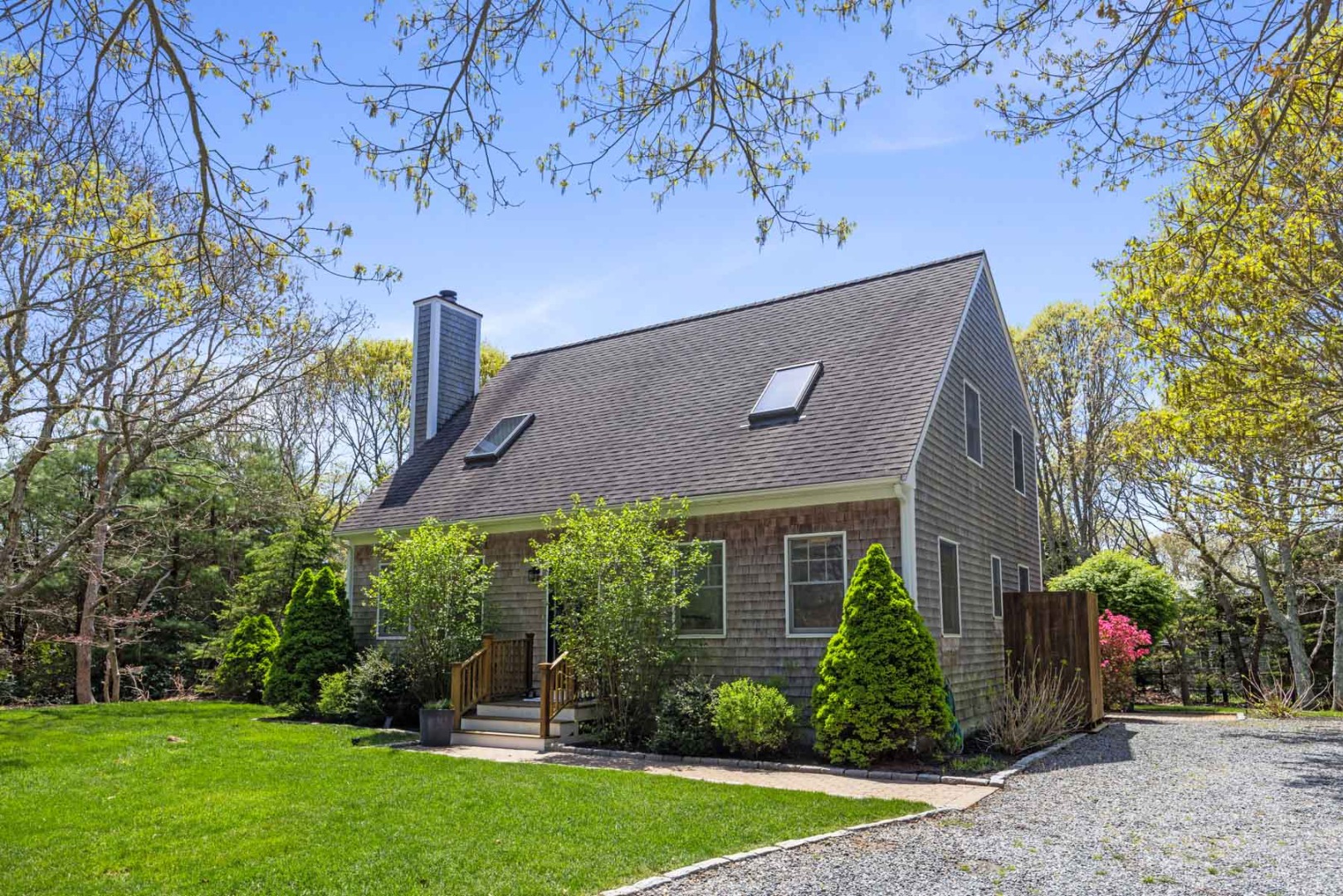 a view of a house with a yard and potted plants