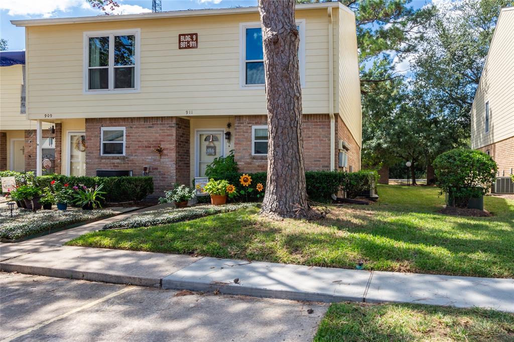 a front view of a house with a yard and potted plants