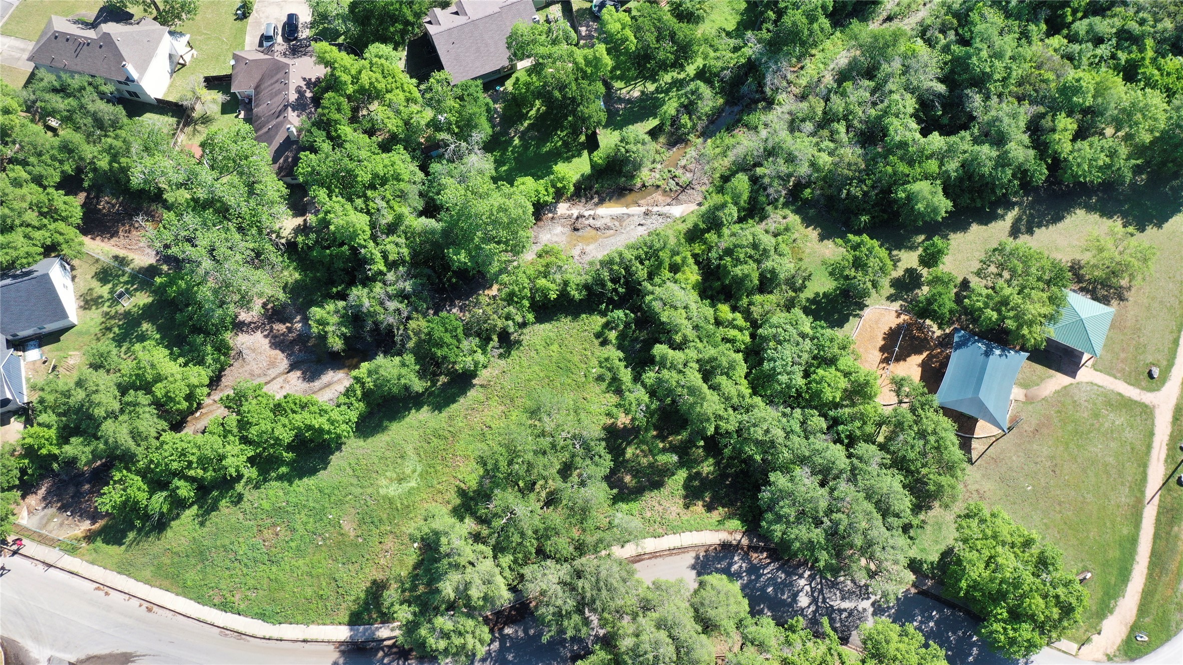 an aerial view of residential house with outdoor space and trees all around