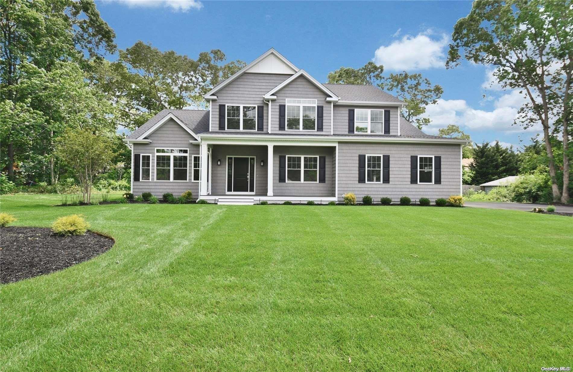 a front view of a house with a garden and trees