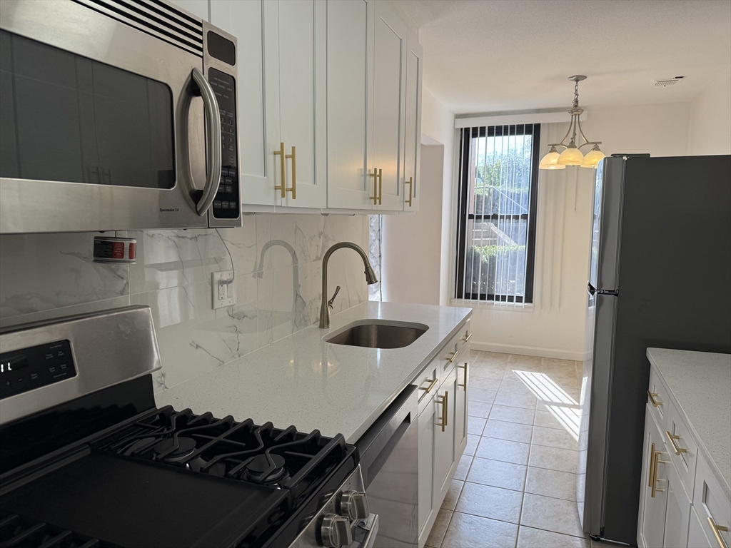 a kitchen with stainless steel appliances a sink stove and refrigerator