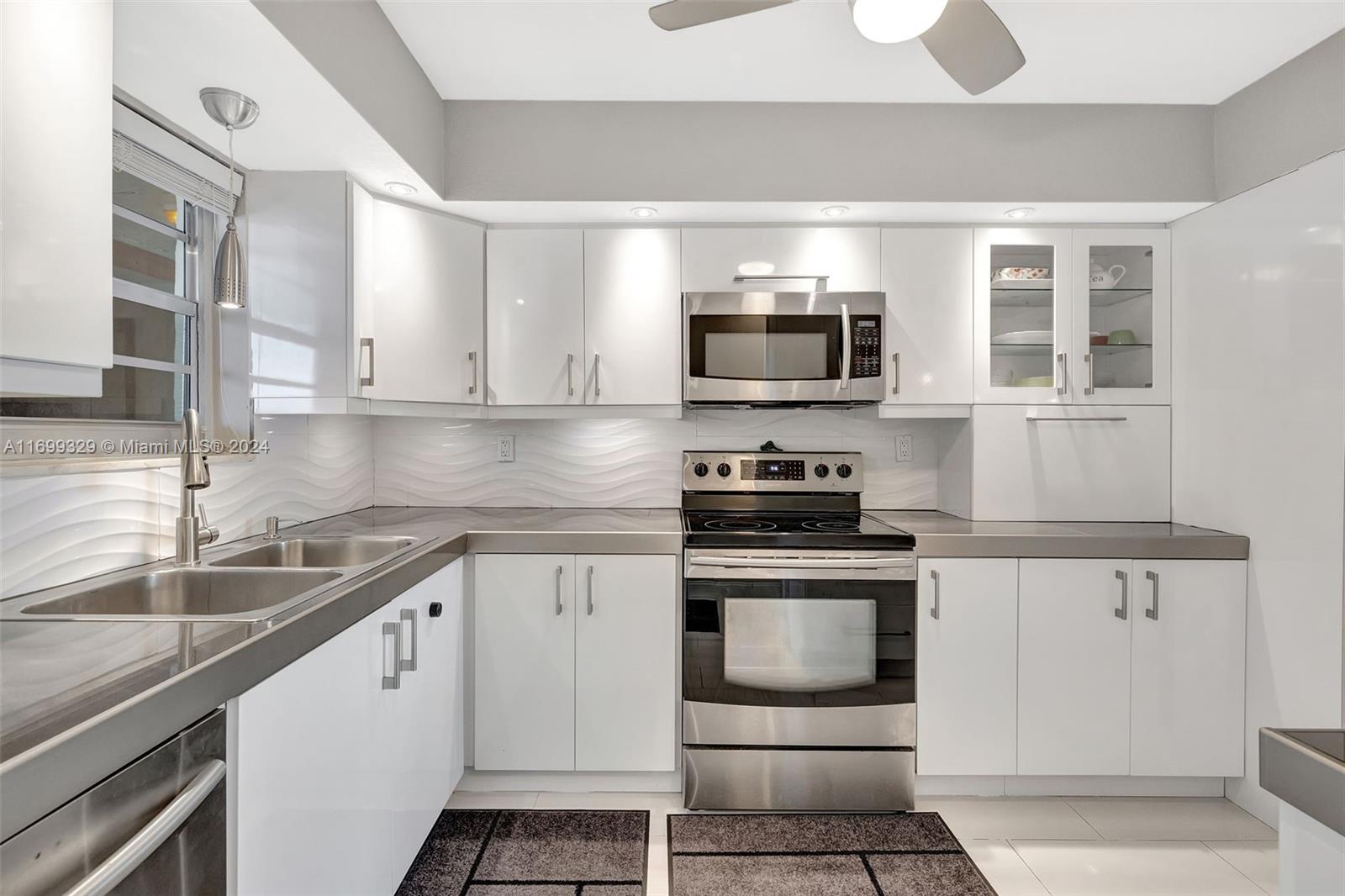 a kitchen with stainless steel appliances granite countertop a sink and a stove