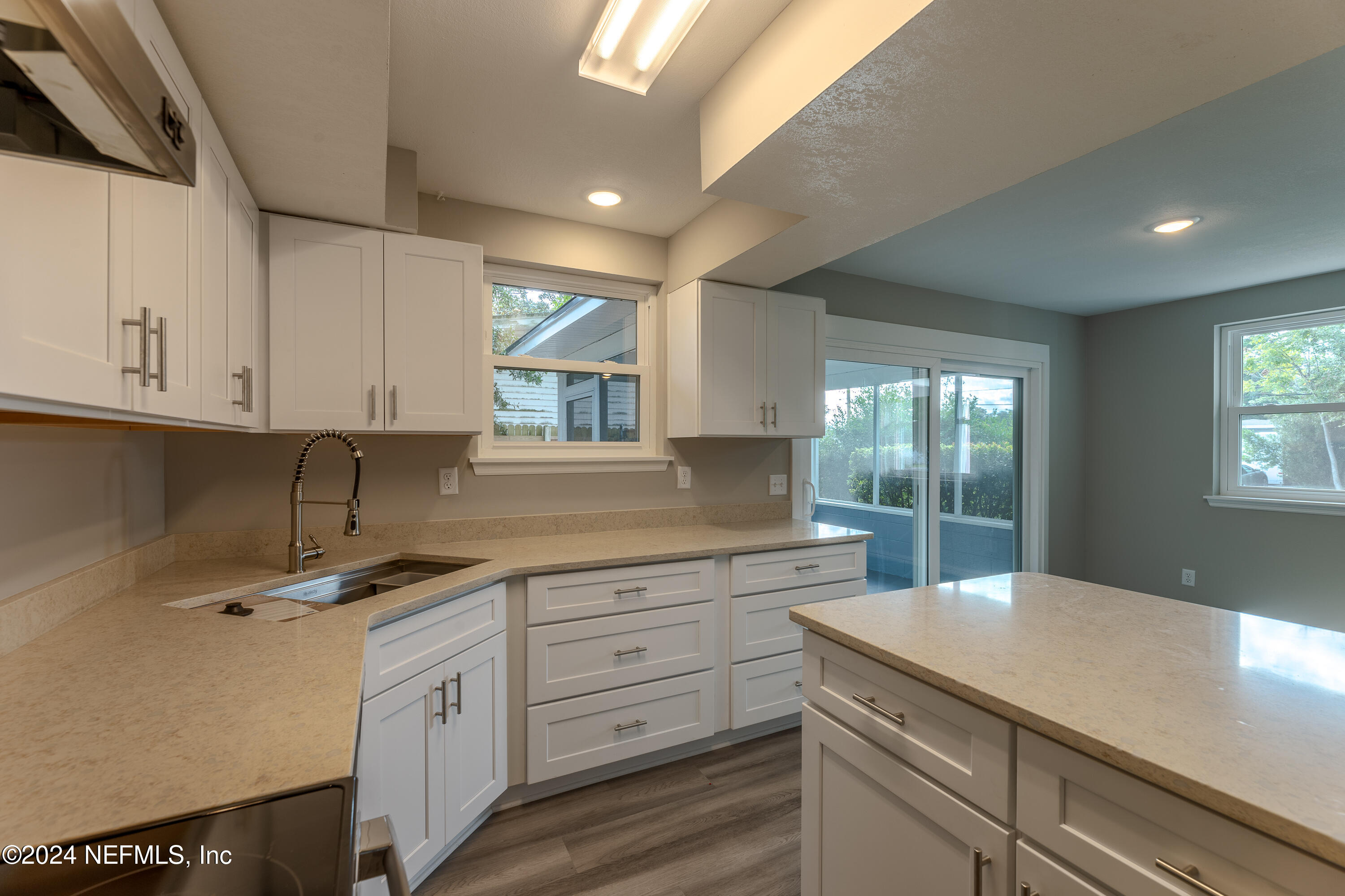 a kitchen with cabinets appliances a sink and a window