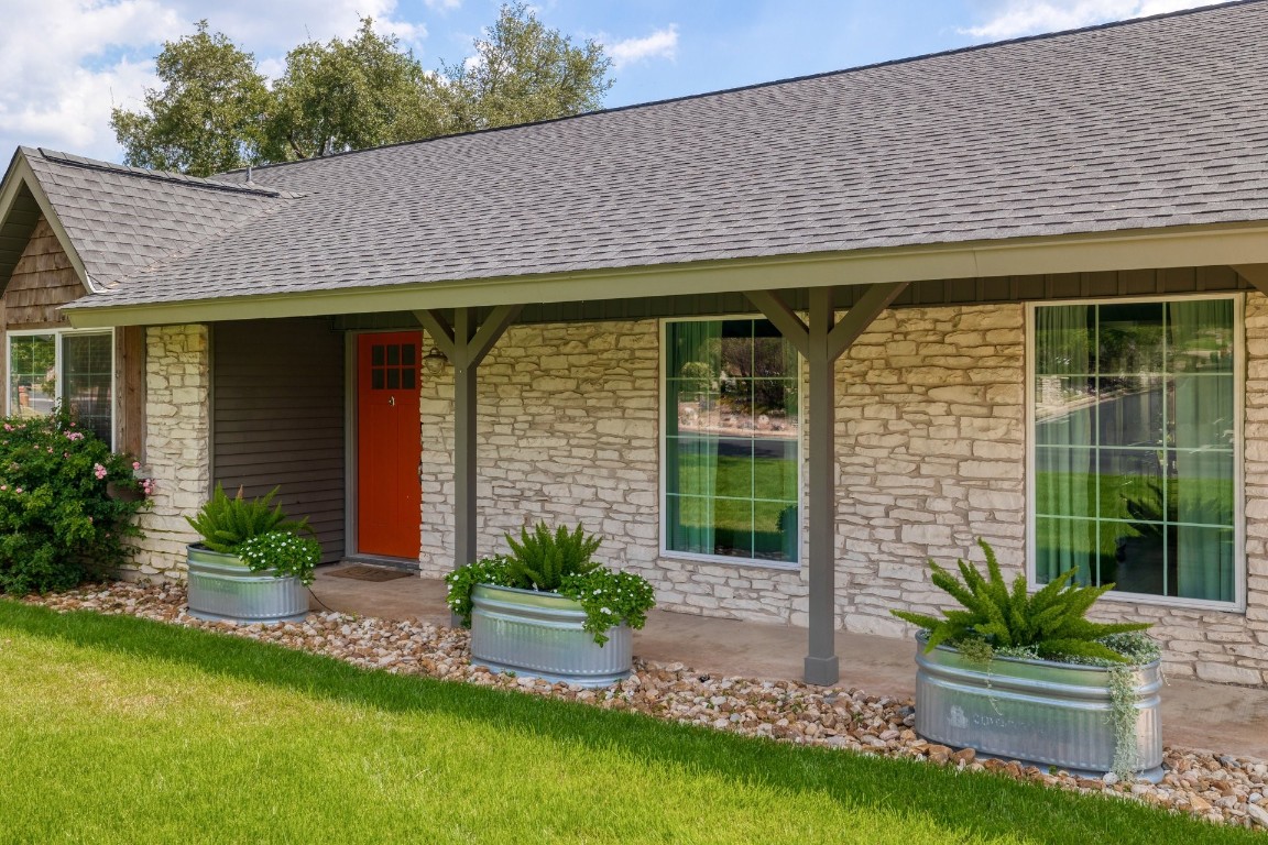 a front view of a house with a garden and plants