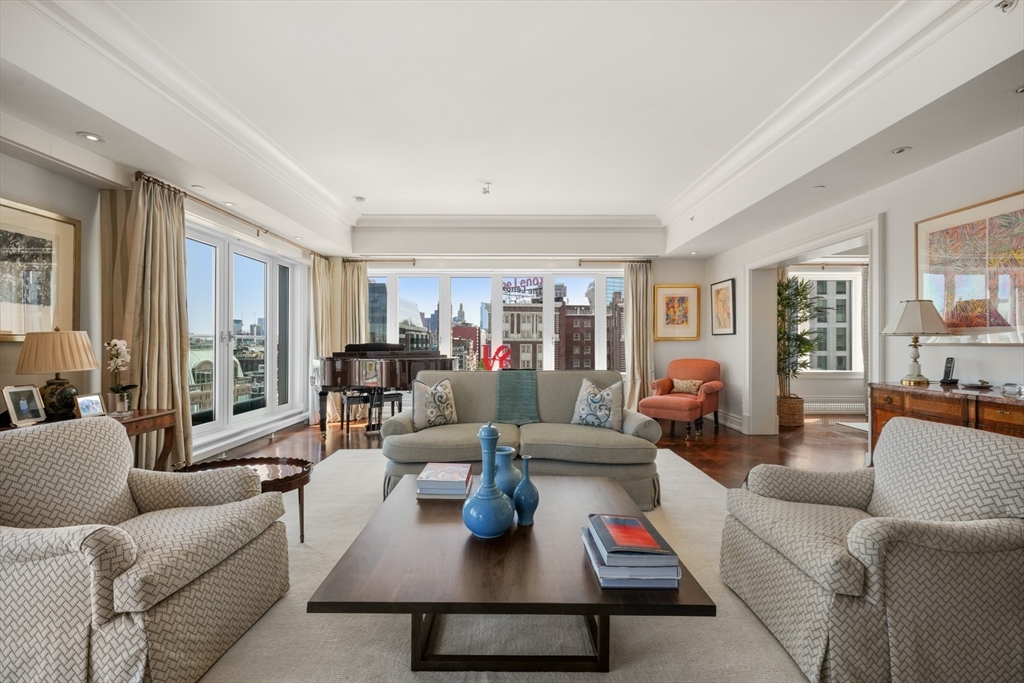 a living room with furniture wooden floor and a large window