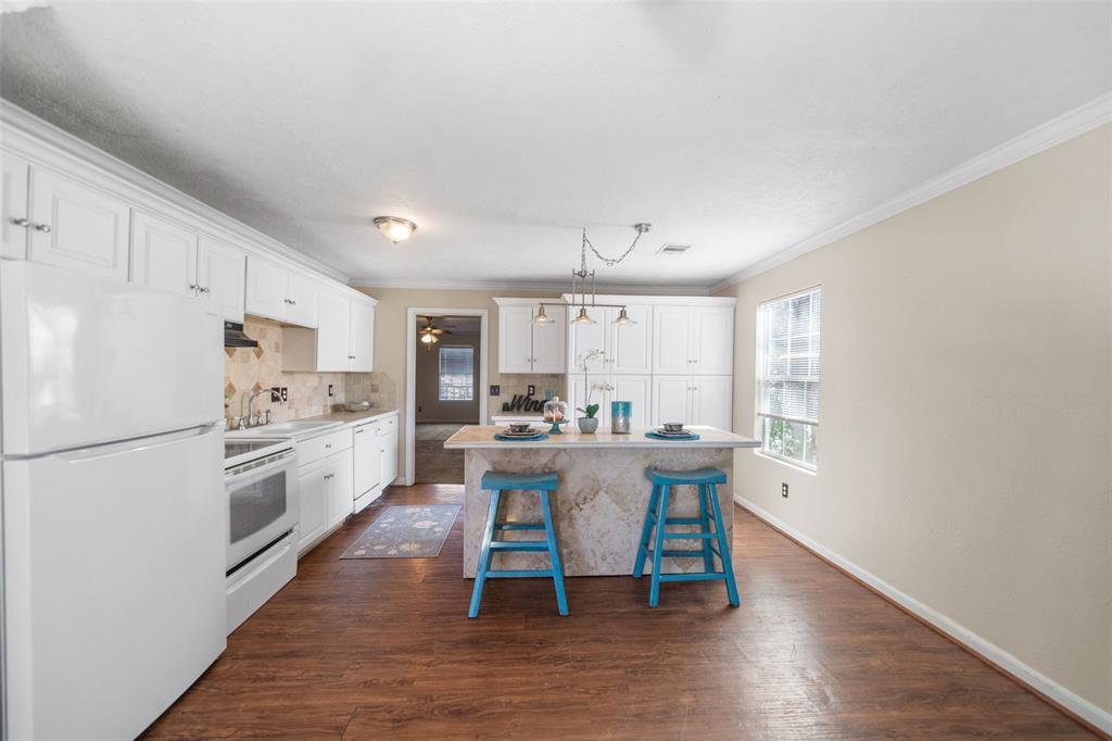 a kitchen with stainless steel appliances a dining table chairs and a refrigerator