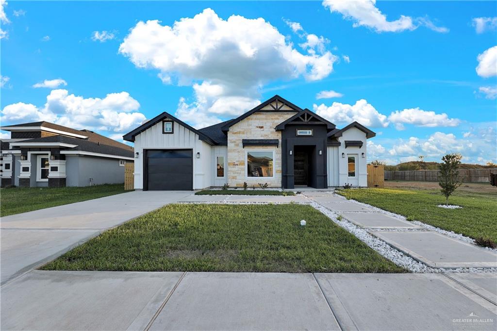 Modern inspired farmhouse with a front lawn and a garage