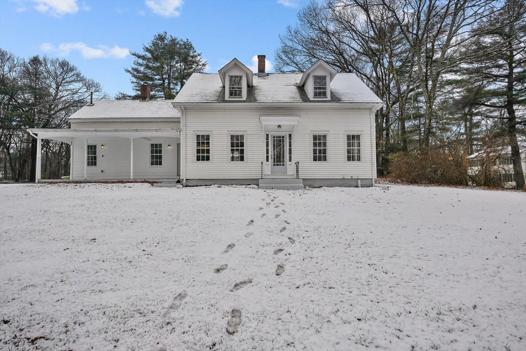 a front view of a house with a yard covered in snow