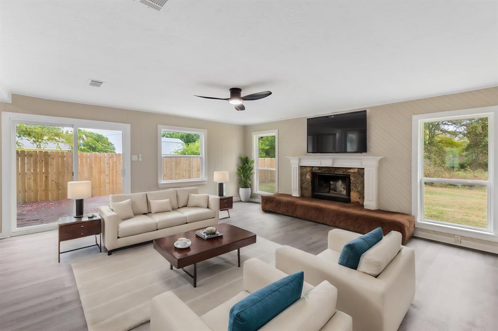 a living room with furniture a large window and a fireplace