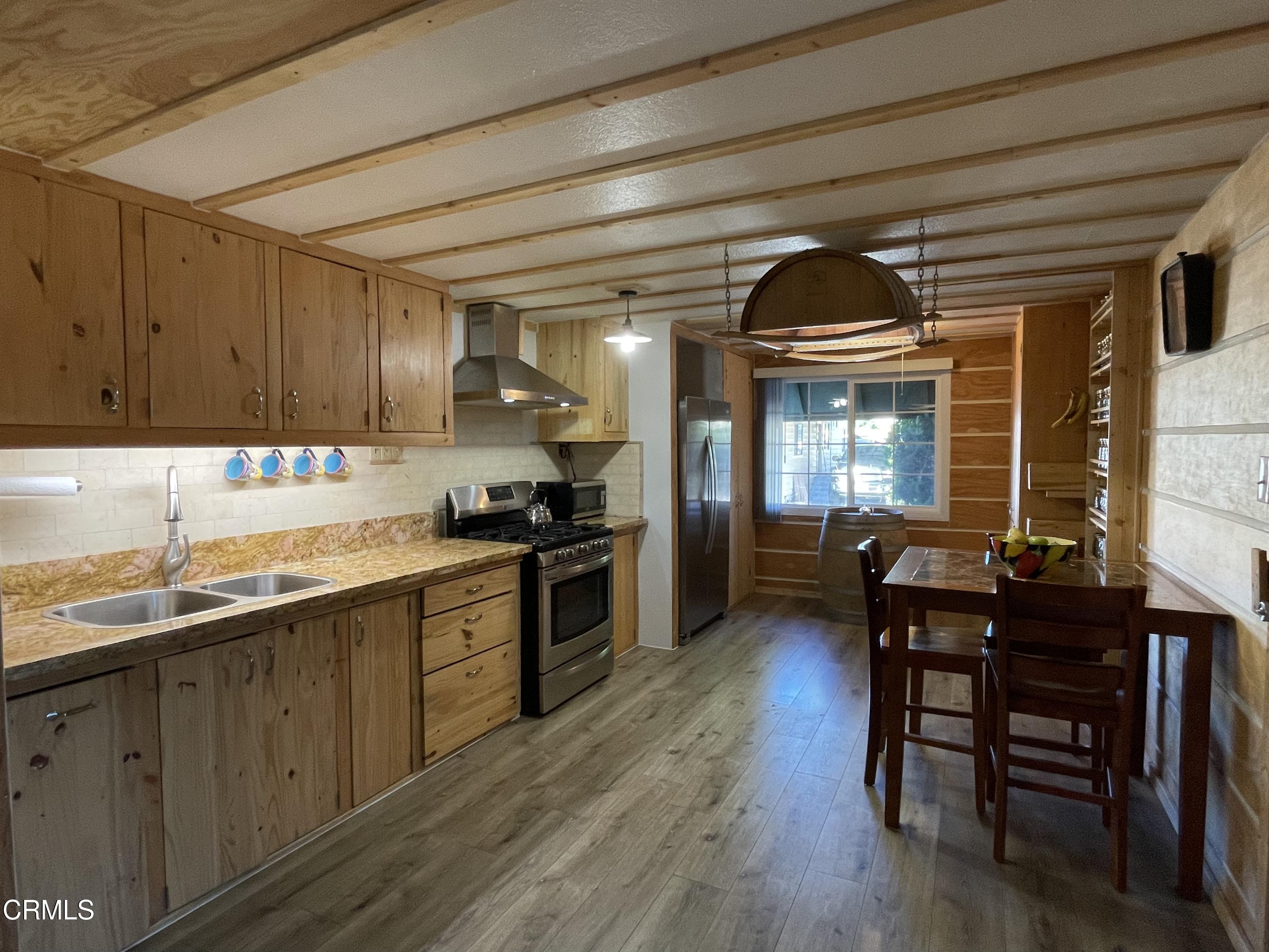 a kitchen with granite countertop wooden floors and wooden cabinets