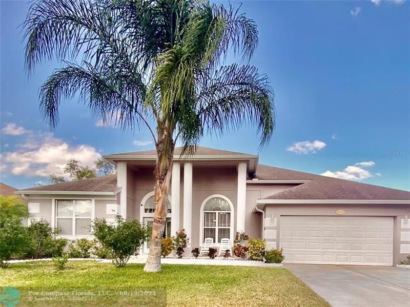 a front view of a house with yard and swimming pool