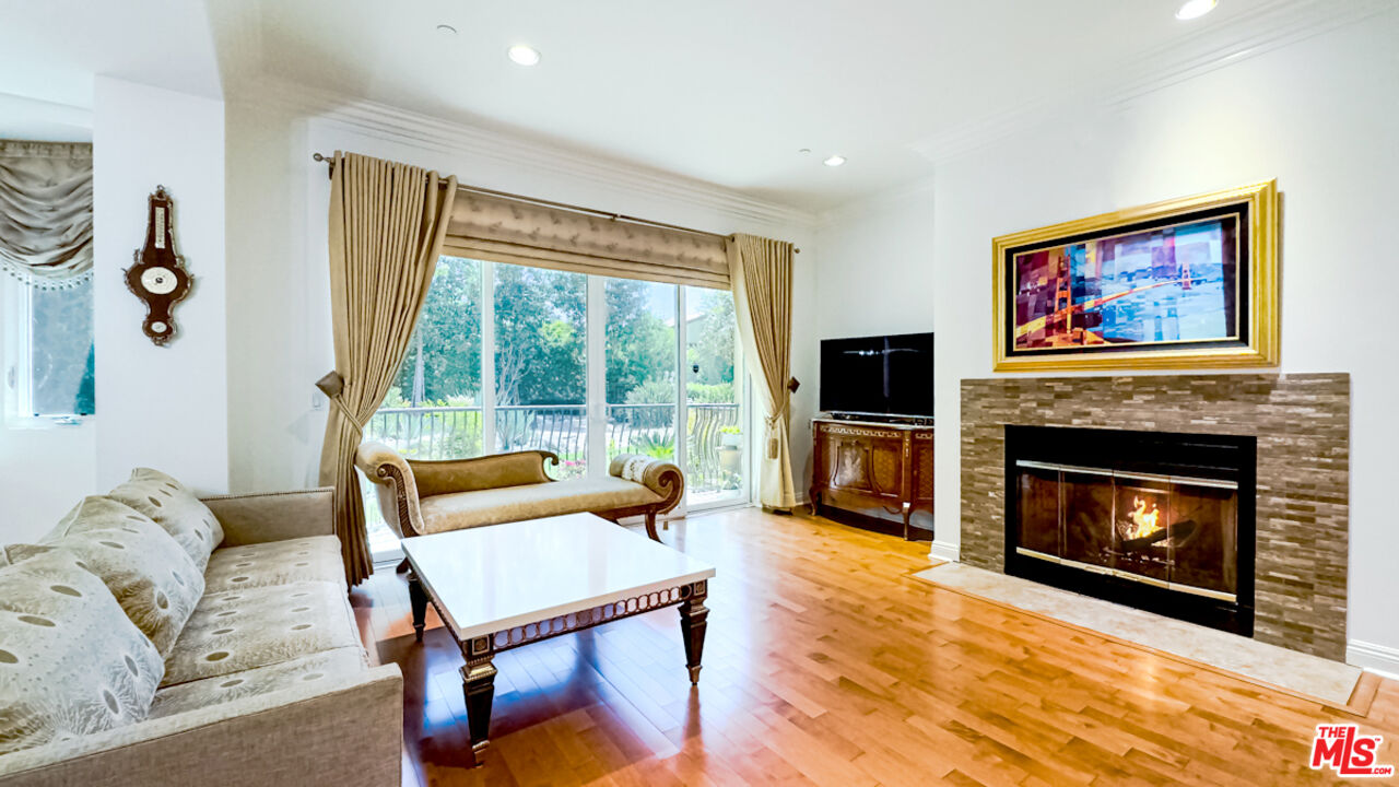 a living room with furniture a flat screen tv and a fireplace