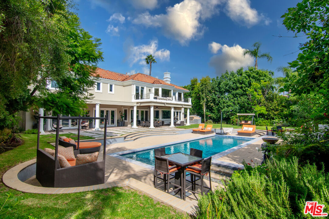 a front view of a house with swimming pool having outdoor seating