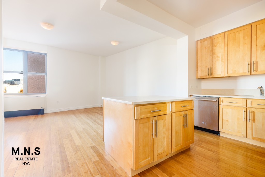 a view of a kitchen with wooden floor and stainless steel appliances