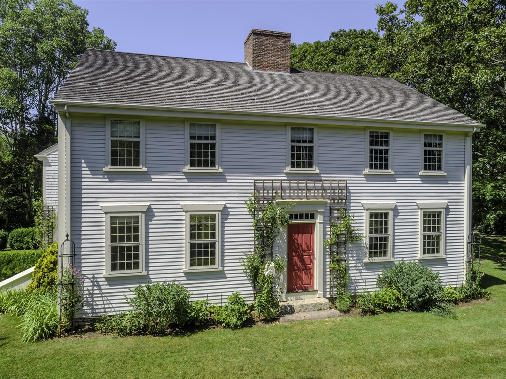 a front view of a house with a yard and plants