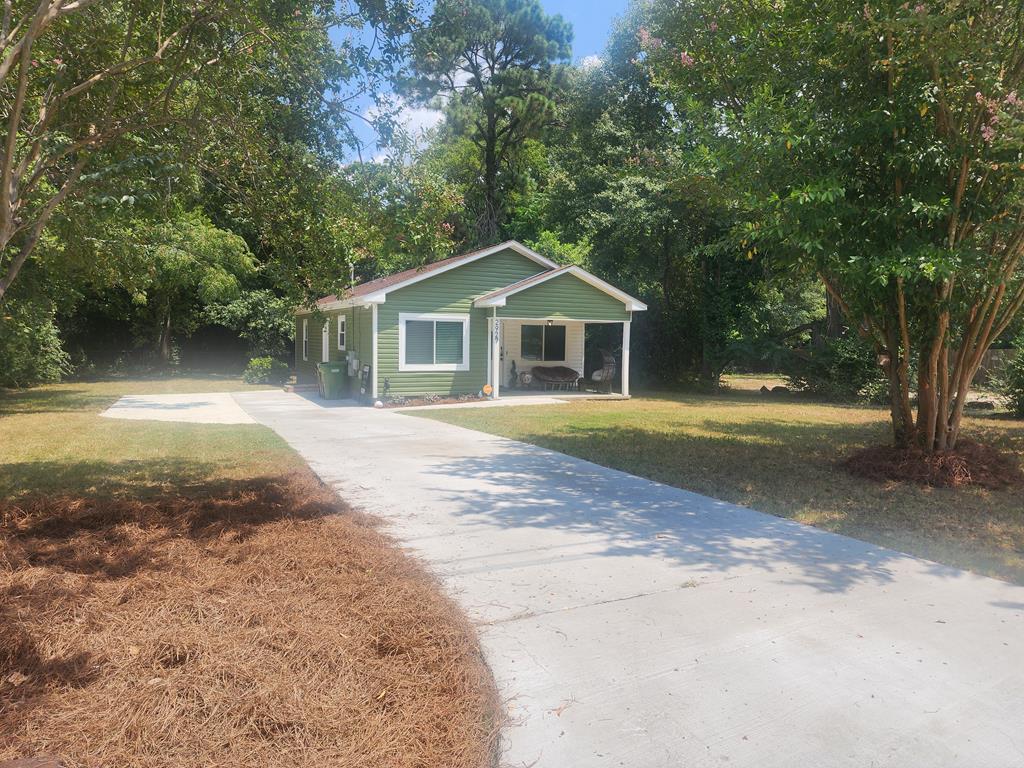 a front view of a house with a yard and trees