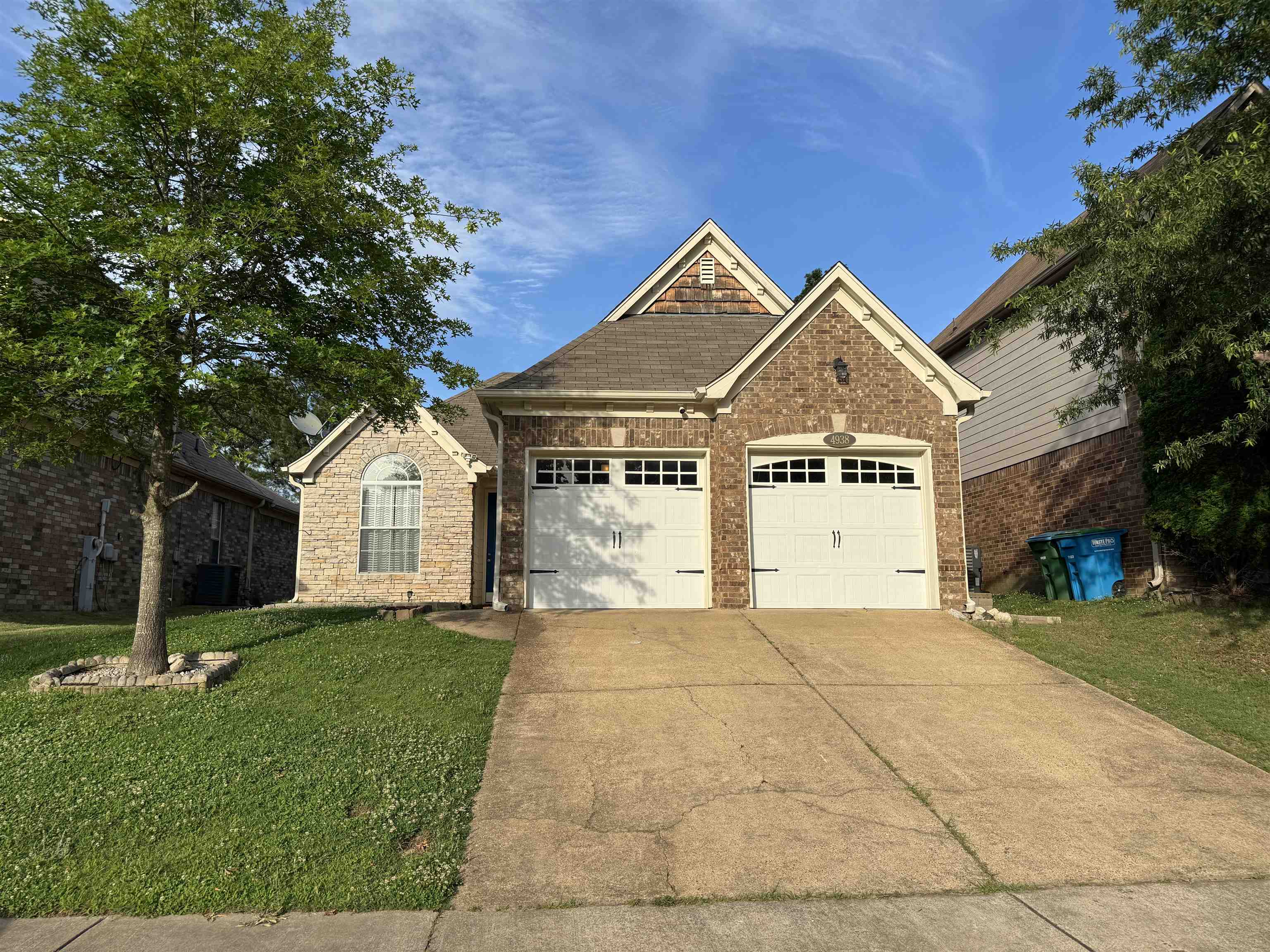 View of front of house featuring a front yard, central AC, and a garage