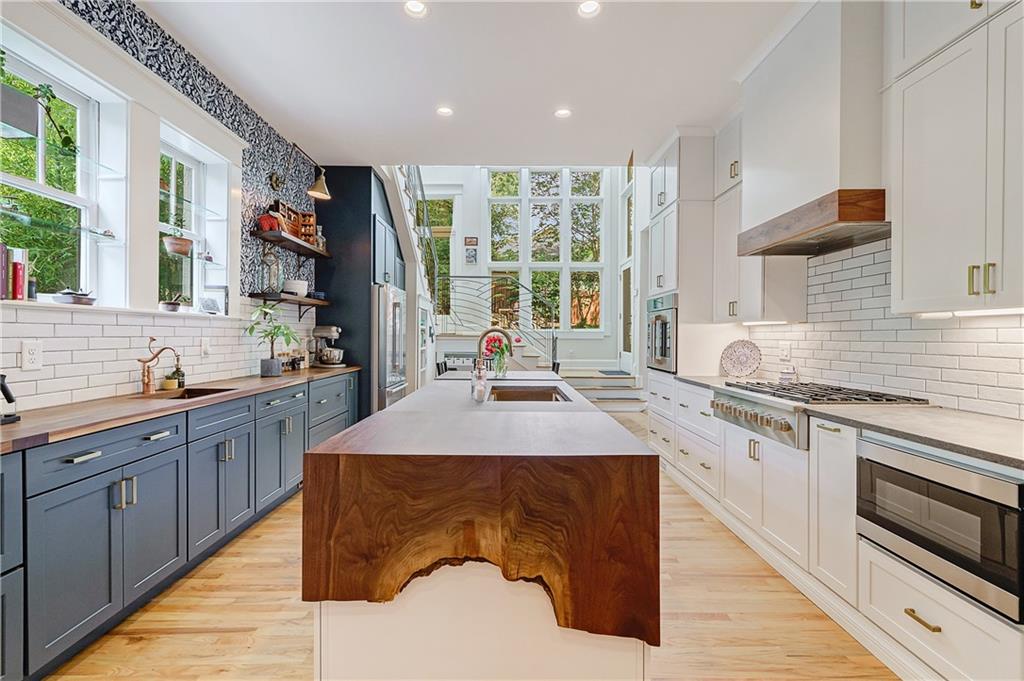 a kitchen with stainless steel appliances granite countertop a sink stove and cabinets