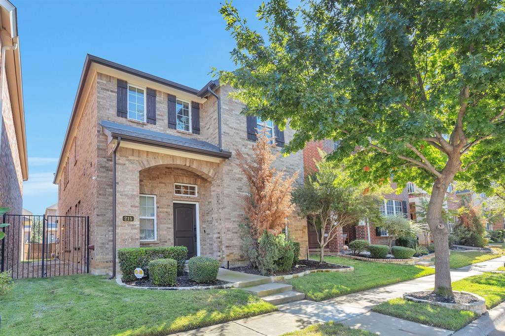 front view of a brick house with a yard