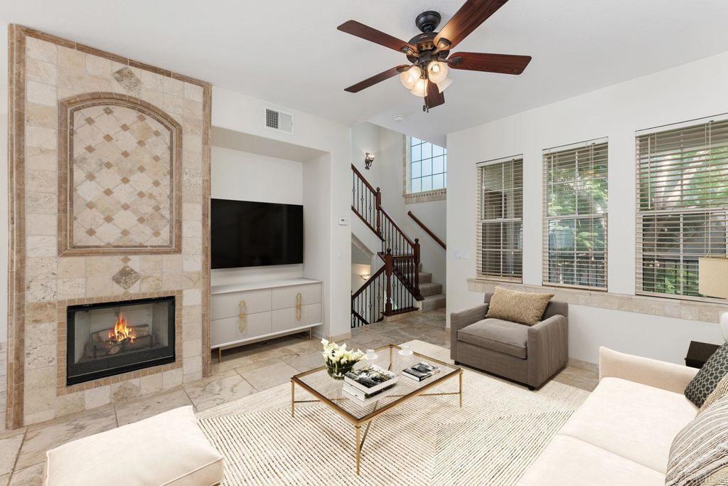 a living room with furniture a flat screen tv and a fireplace