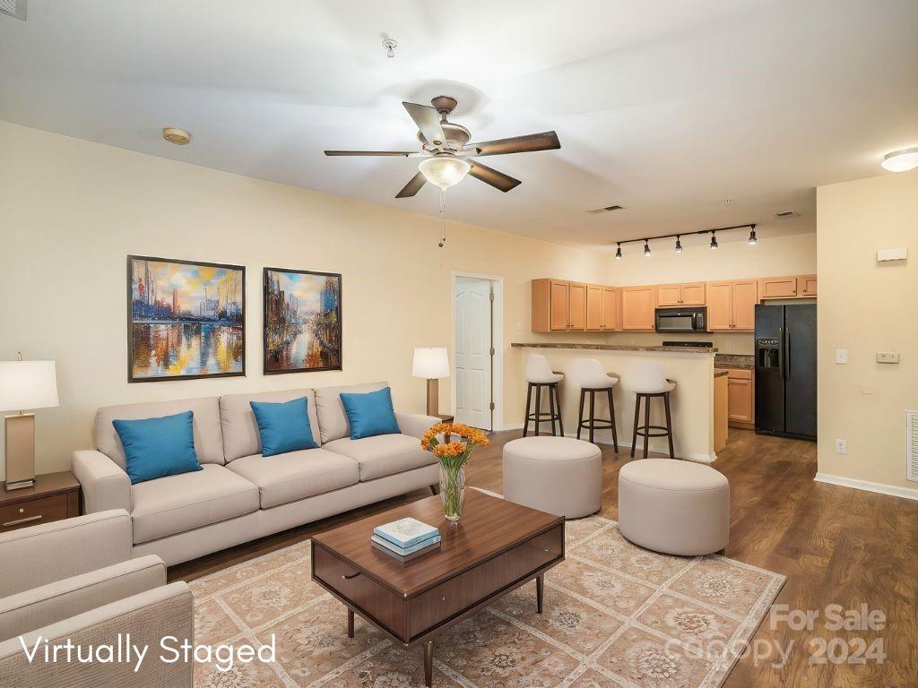 a living room with furniture and a view of kitchen