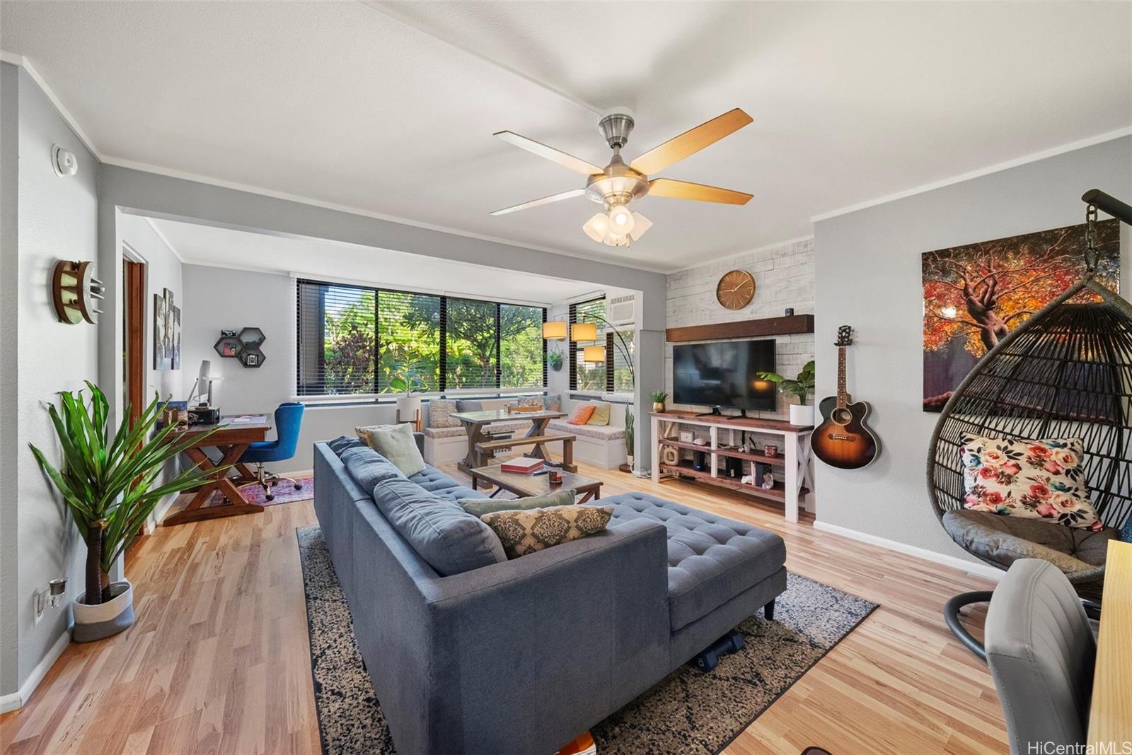 a living room with furniture kitchen view and a large window