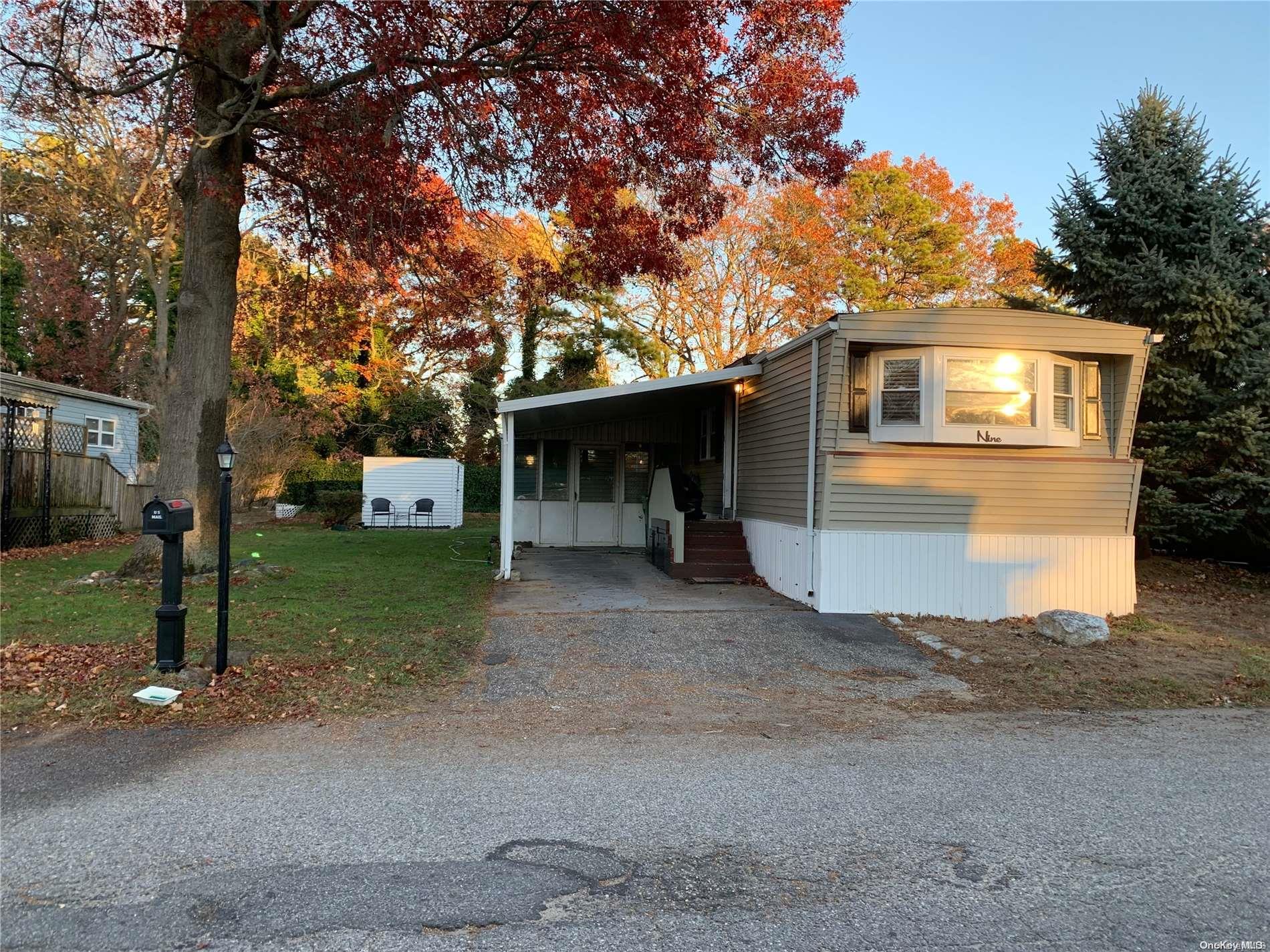 a view of a house with a yard and large tree