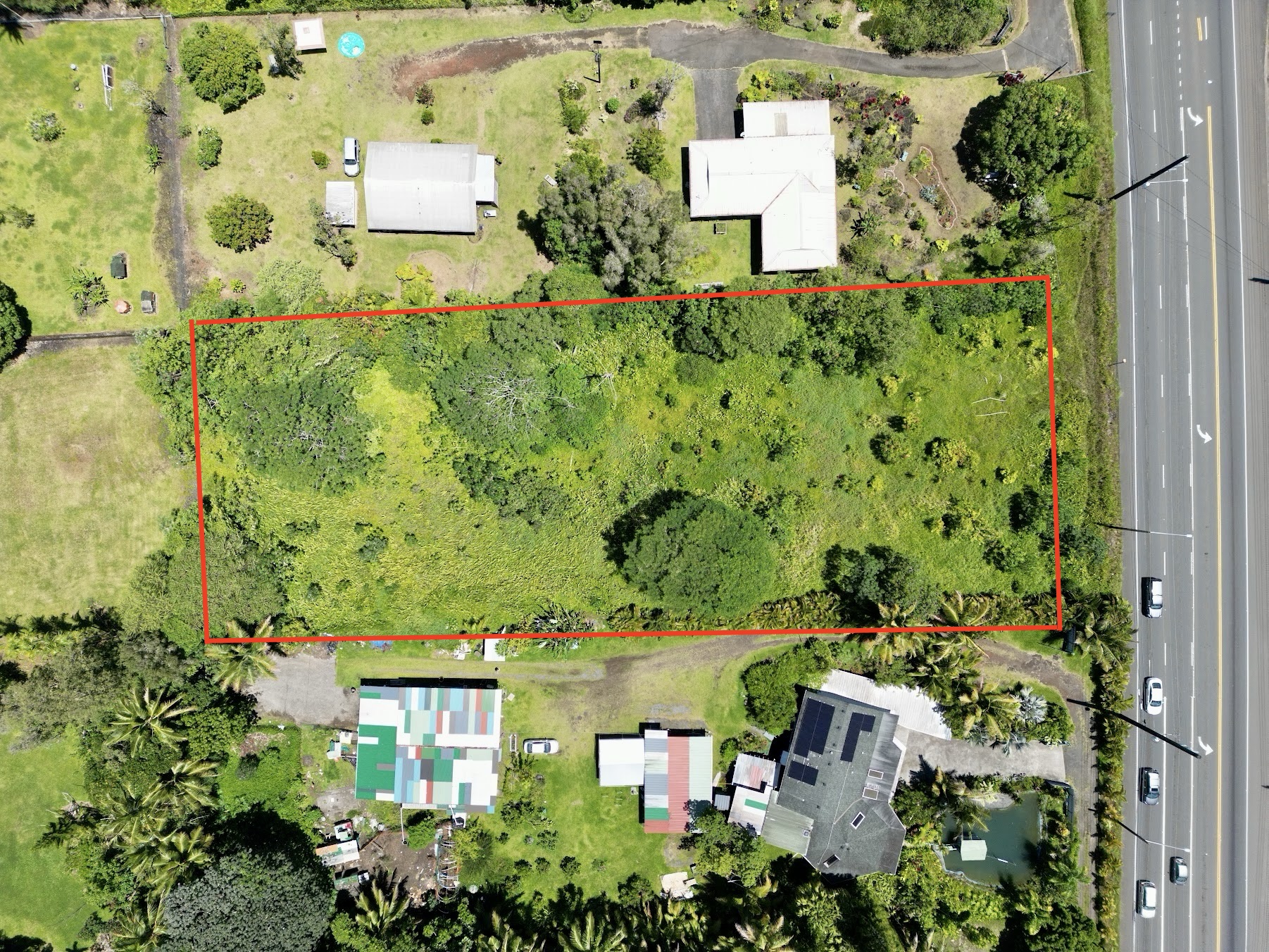 an aerial view of a house with a yard and trees all around