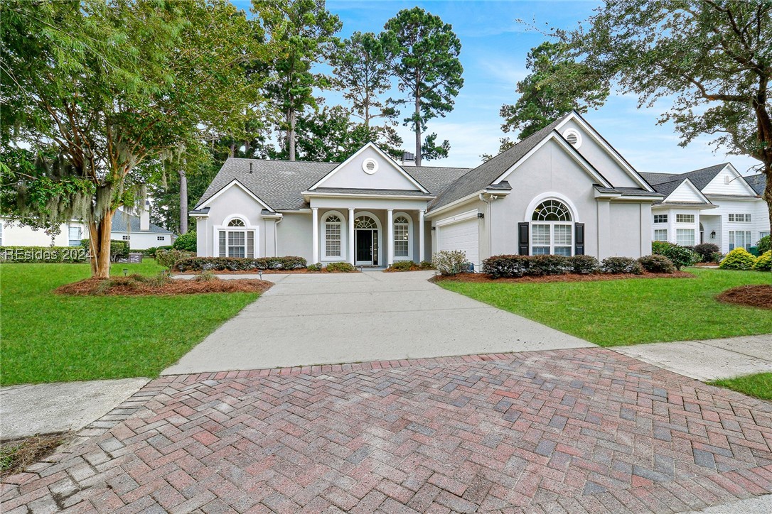 View of front of house with a front yard and a gar