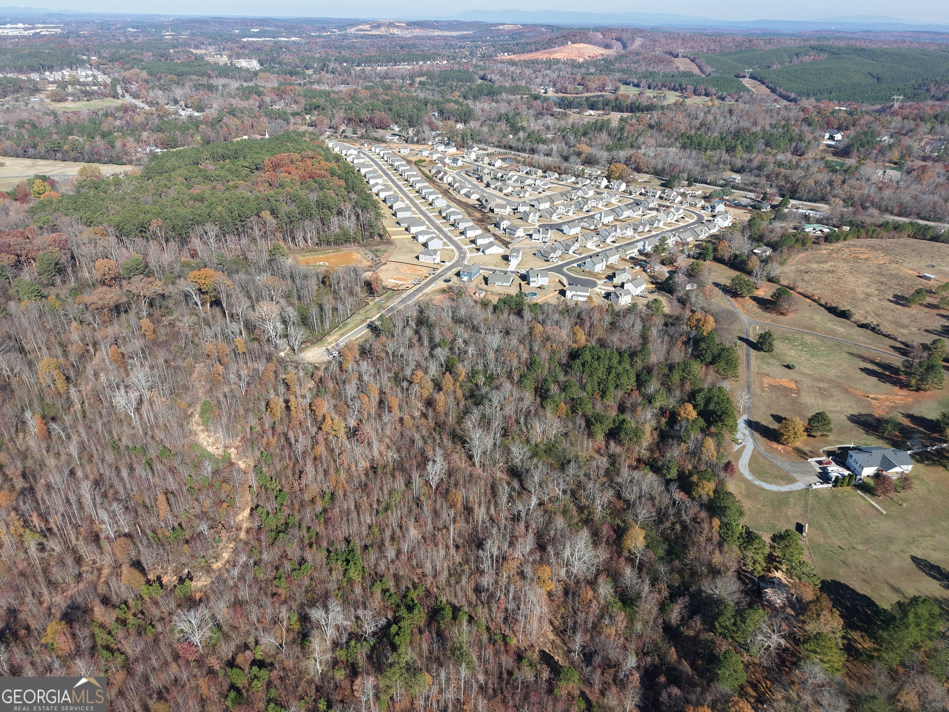 an aerial view of residential houses with outdoor space and trees