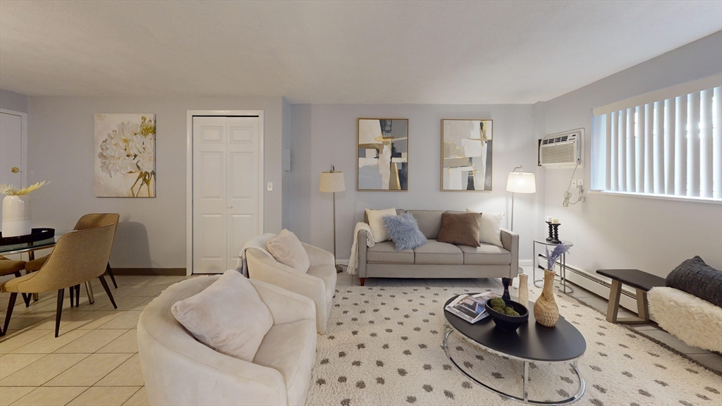 a living room with furniture a rug and a window