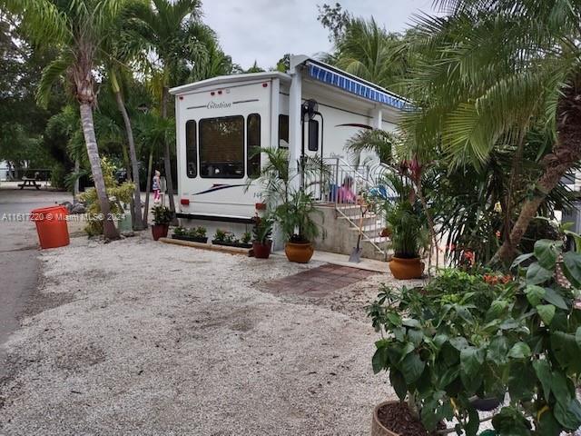 a front view of a house with a yard and potted plants