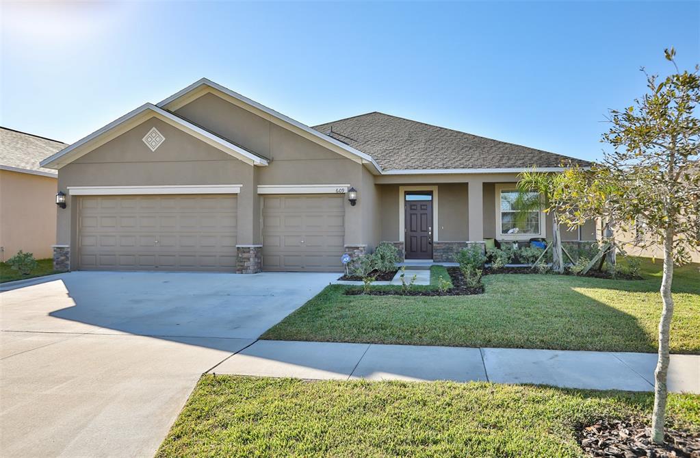 a front view of a house with a yard and garage