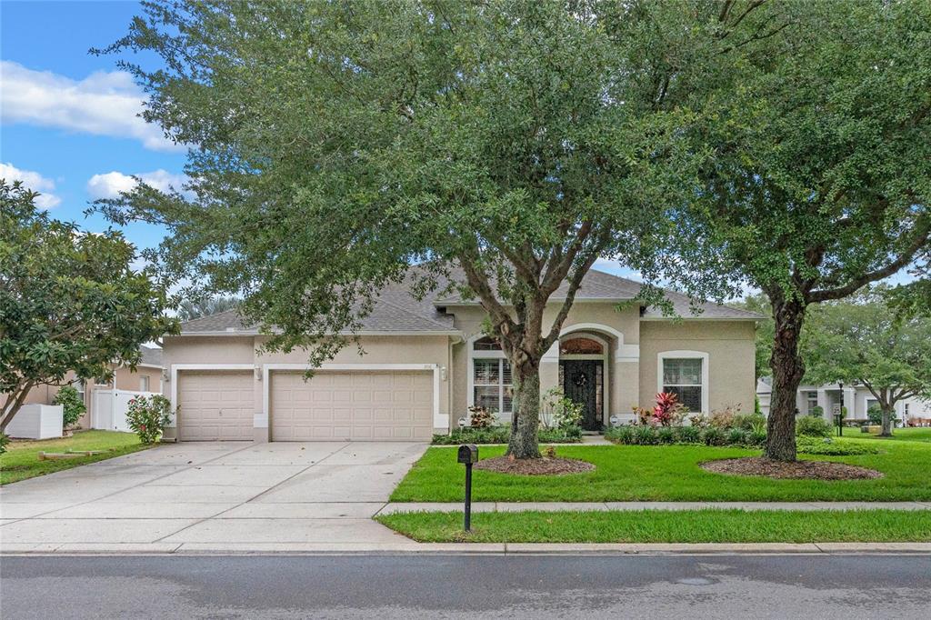 a front view of a house with a yard and a garage