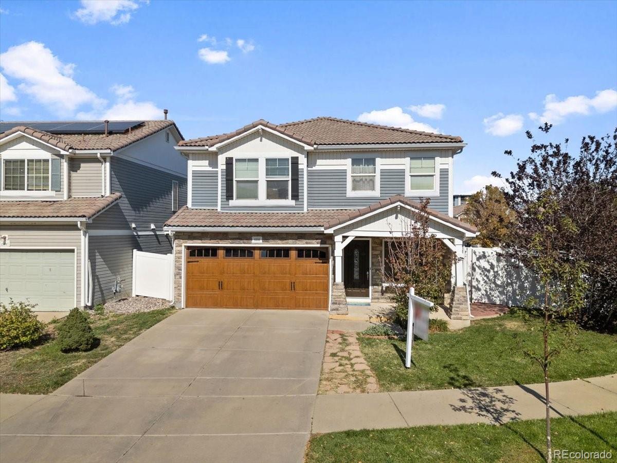 a front view of a house with a yard and trees