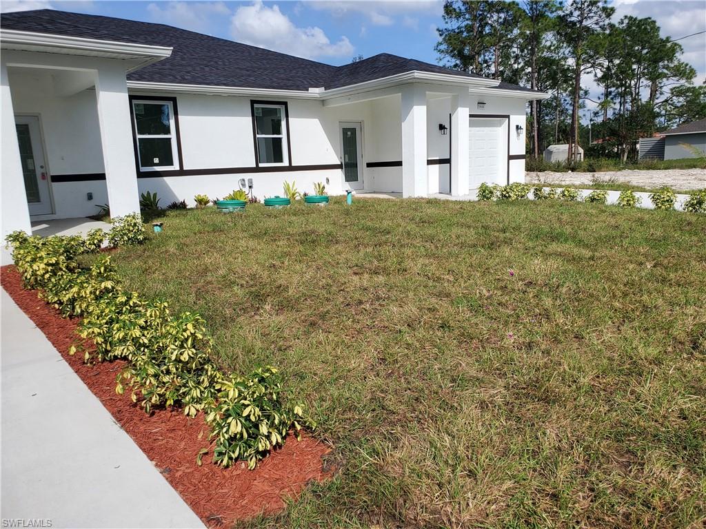 a view of a house with a large tree and a yard