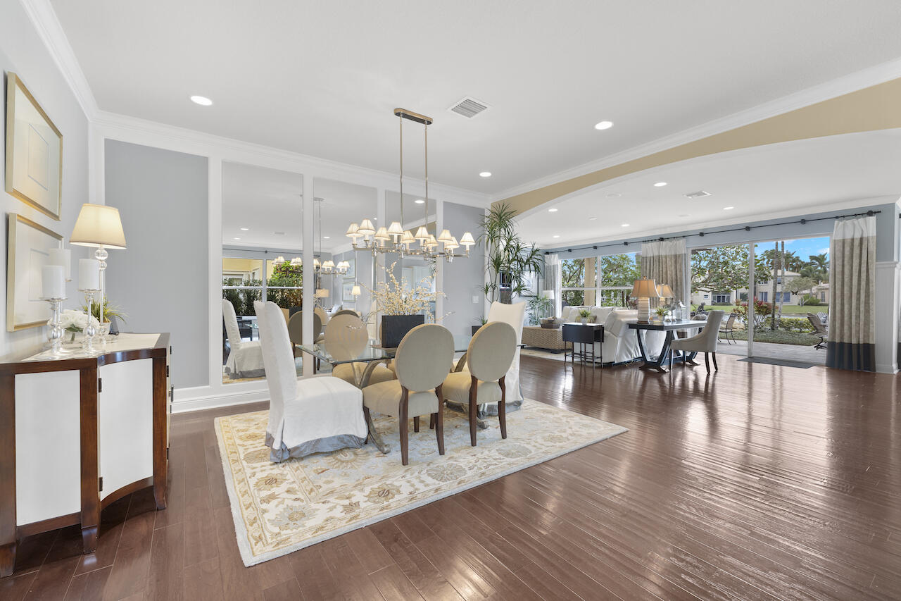 a view of a dining room and livingroom with furniture wooden floor a chandelier